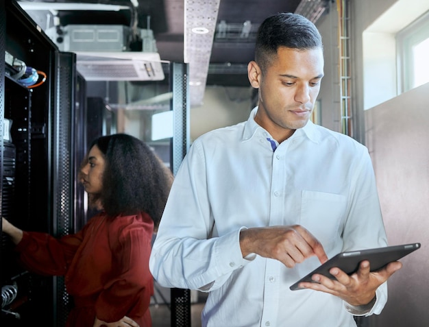 Sala server di gestione e tablet con uomini d'affari nel data center per la sicurezza informatica del cloud computing e la rete hardware Tecnologia internet e con addetto alla manutenzione per l'innovazione