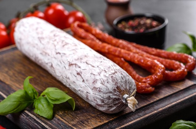 Salame di salsiccia secca spagnola su fondo di cemento scuro. Preparazione di buonissimi panini freschi