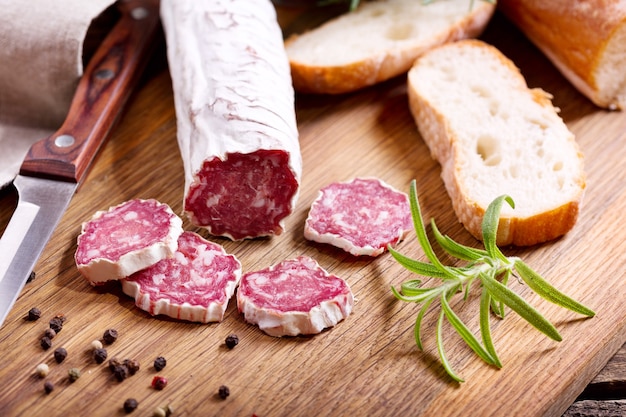 Salame francese al rosmarino su tavola di legno