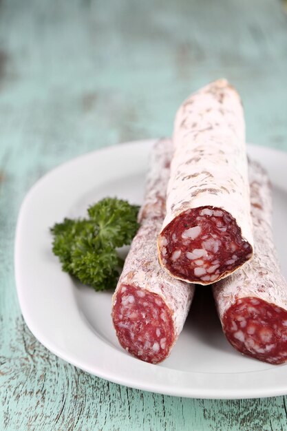 Salame italiano su piatto su sfondo di legno