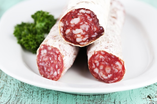 Salame italiano su piatto su sfondo di legno