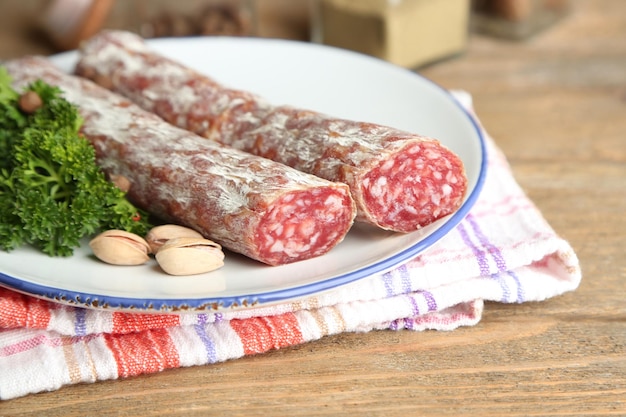Salame italiano su piatto su sfondo di legno