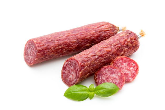 Salame salsiccia affumicata, foglie di basilico e pepe in grani isolati su priorità bassa bianca.