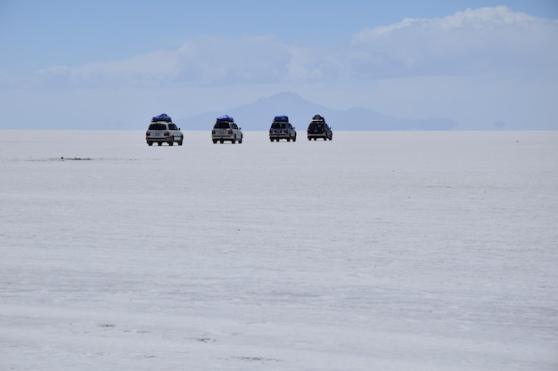 Salar de Uyuni Bolivia Auto fuoristrada che guidano attraverso la distesa salata Salar de Uyuni in Bolivia