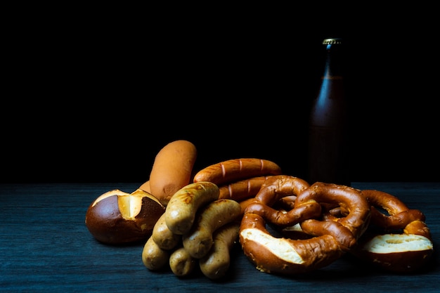 salatini salatini e una bottiglia di birra in legno scuro stile cibo sfondo