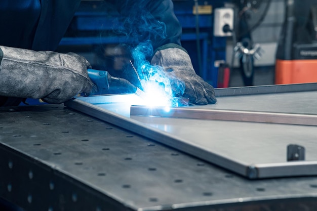 Saldatore al lavoro saldatura di parti metalliche in officina