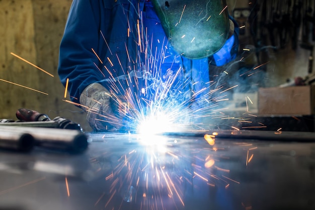 Saldatore che lavora in una fabbrica industriale