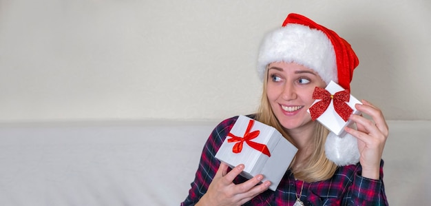 Saldi di Natale. Felice giovane donna in possesso di scatole regalo di Natale davanti al viso