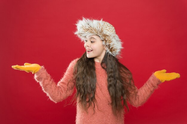 Saldi di Natale. sentirsi a proprio agio e accogliente in qualsiasi condizione atmosferica. vacanze invernali e vacanze. bambino con cappello con paraorecchie. bambino in guanti e maglione lavorati a maglia. infanzia. la ragazza teenager felice indossa vestiti caldi.