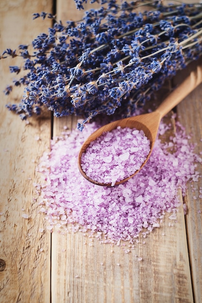 Sale di lavanda con prodotti termali naturali e decorazioni per il bagno su fondo in legno