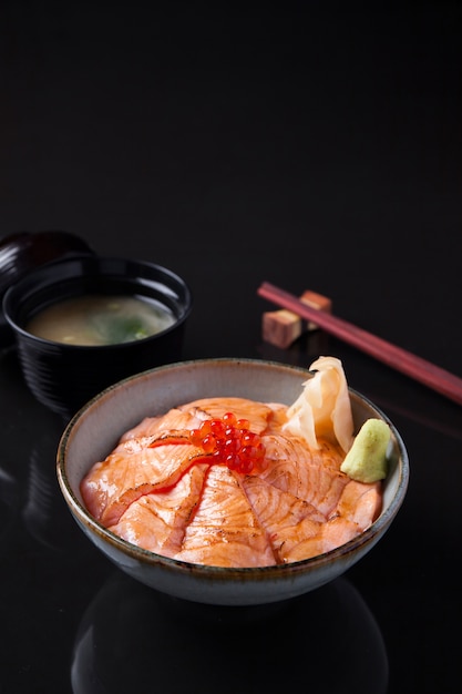 Salmon Sashimi Rice Bowl su un tavolo scuro