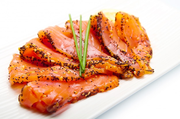 salmone affumicato su piatto bianco con erba cipollina