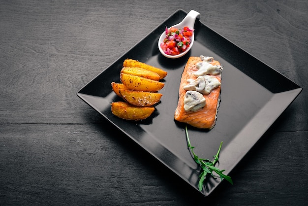 Salmone al forno con salsa di funghi e patate su sfondo di legno Vista dall'alto Spazio libero