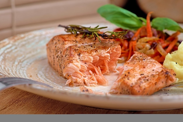 Salmone al forno grigliato con purè di patate e insalata su fondo di legno