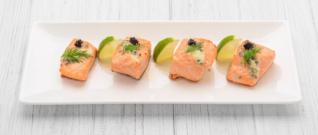 Salmone alla griglia, patate lesse e verdure su un piatto bianco