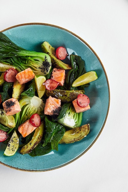 Salmone con carciofi, avocado, primo piano, servito dallo chef con salmone al forno e avocado con carciofi in salsa di limone.