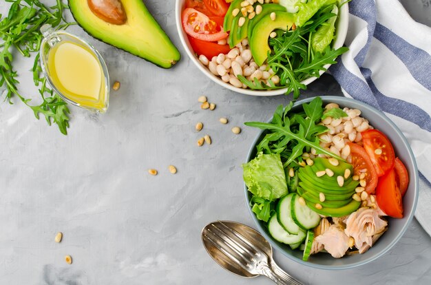 Salmone con insalata di fagioli bianchi, pomodori, cetrioli, avocado e rucola