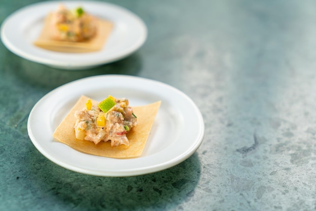 Salmone con salsa di insalata di frutta su cracker