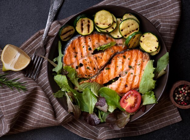 Salmone cotto con verdure su sfondo scuro