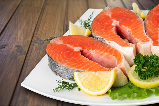 Salmone crudo fresco con sale e limone su fondo di legno