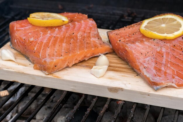Salmone della plancia del cedro con la cottura del limone sulla griglia