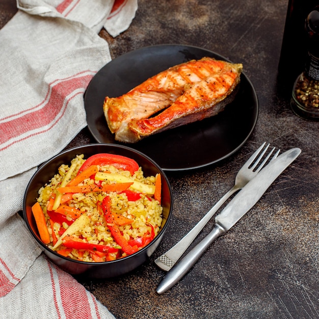 Salmone e bulgur freschi alla griglia con verdure in ciotola nera