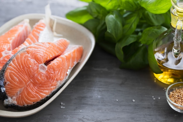 Salmone fresco con erbe sul piatto bianco su ceramica