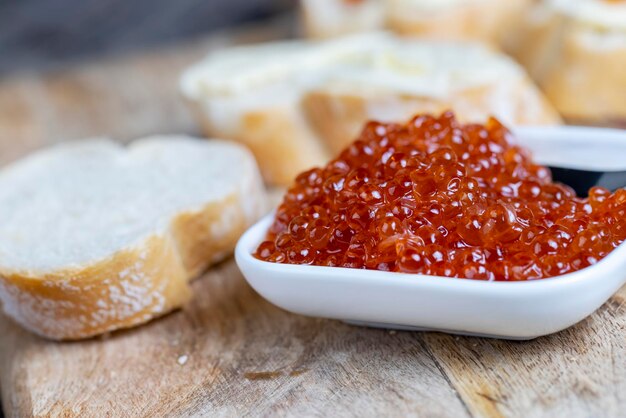 Salmone rosso o caviale di trota con baguette bianca e burro per fare panini con pagnotta di burro e vero caviale rosso