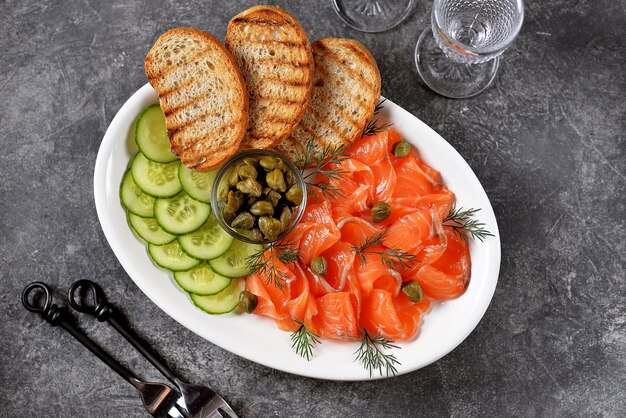 Salmone salato, cetriolo, capperi, aneto e pane grigliato