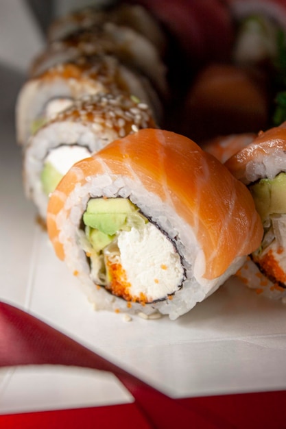 salmone tonno chuka gamberetti anguilla nigiri gunkan sushi rolls in scatola bianca su sfondo rosso