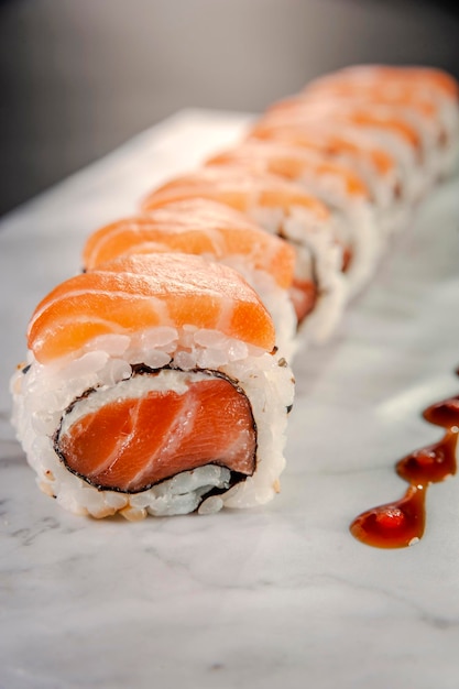 Salmone Uramaki su lastra di marmo. Avvicinamento.