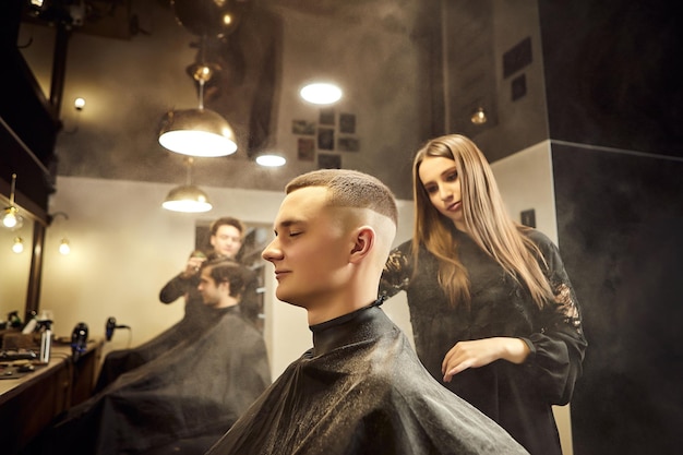 Salon Uomo su una poltrona da barbiere Il parrucchiere serve il cliente nel negozio di barbiere Il concetto di cosmetologia maschile