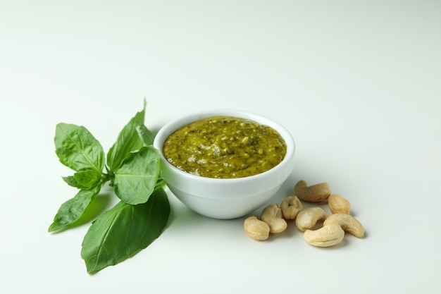 Salsa al pesto e ingredienti su sfondo bianco