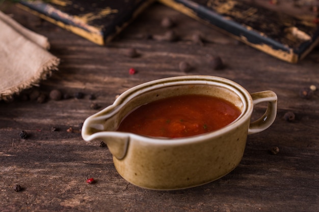 Salsa al pomodoro con le verdure in una casseruola su legno rustico