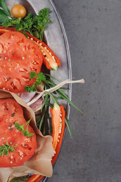 Salsa al pomodoro ed ingredienti per la sua cottura sul piatto di metallo.