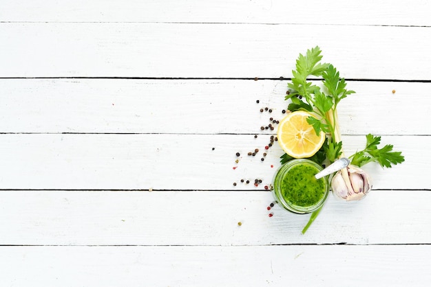 Salsa al prezzemolo verde, Ingredienti per la salsa chimichurri. Su uno sfondo di legno bianco. Vista dall'alto. spazio libero per il tuo testo.