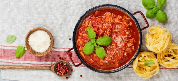 Salsa bolognese italiana tradizionale in casseruola un vecchio fondo di legno scuro. Vista dall'alto, copia spazio