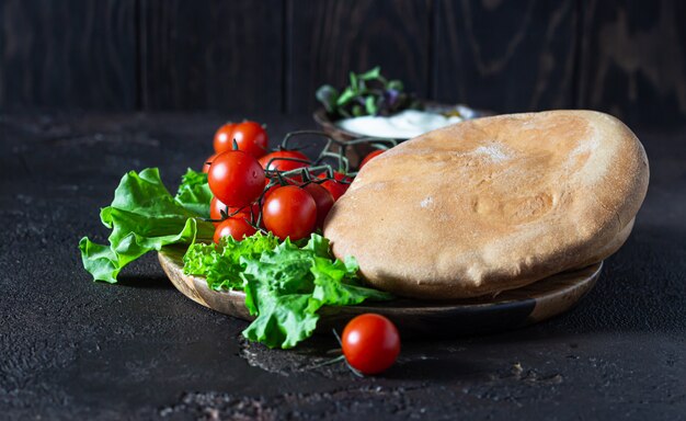 Salsa di crema di formaggio mediorientale con olio d'oliva, spezie ed erbe aromatiche con pane pita, pomodorini e lattuga