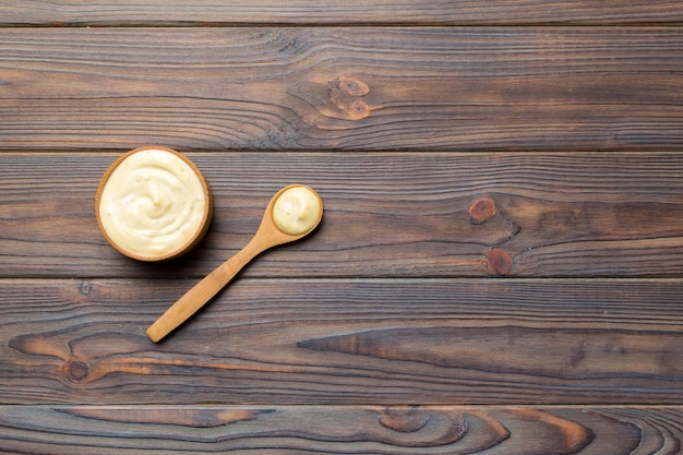 Salsa di formaggio in una ciotola di legno con un cucchiaio su sfondo di legno Vista dall'alto con spazio per la copia