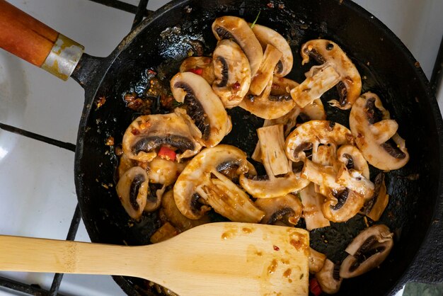 Salsa di funghi e peperone rosso in padella cottura con mescolando palette di legno