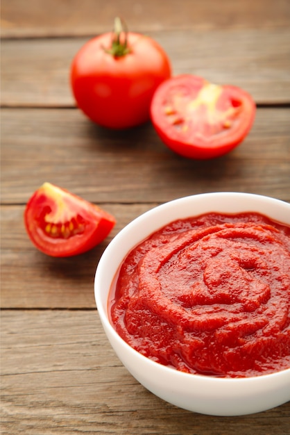 Salsa di ketchup di pomodoro in una ciotola con i pomodori