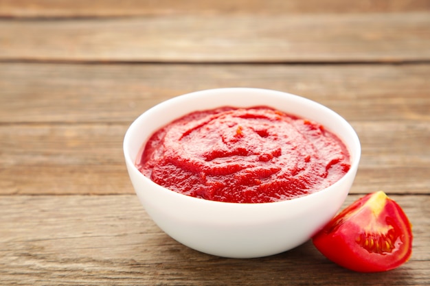 Salsa di ketchup di pomodoro in una ciotola con i pomodori