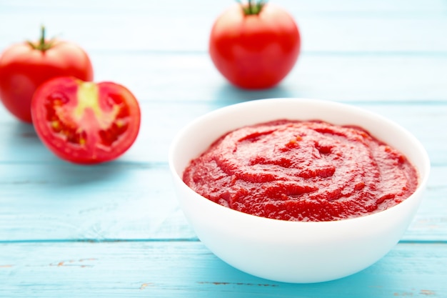 Salsa di ketchup di pomodoro in una ciotola con i pomodori