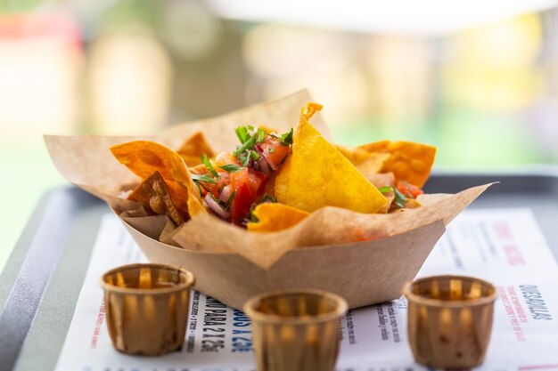 Salsa di nachos in un caffè di strada su un piatto di carta con salse