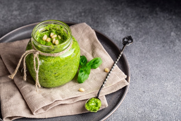 Salsa di pesto fatta in casa su uno sfondo grigio