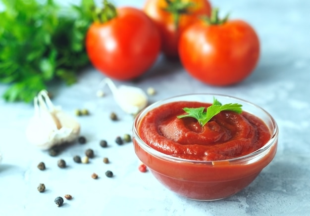 Salsa di pomodoro classica con spezie pepe e aglio su fondo di cemento