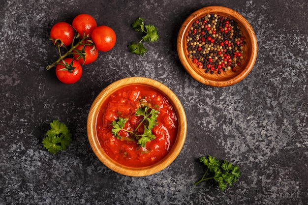 Salsa di pomodoro con aglio e prezzemolo in una ciotola di legno