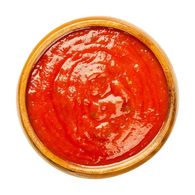 Salsa di pomodoro con erbe aromatiche in una ciotola di legno