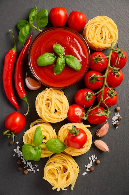 Salsa di pomodoro con pasta su sfondo nero.