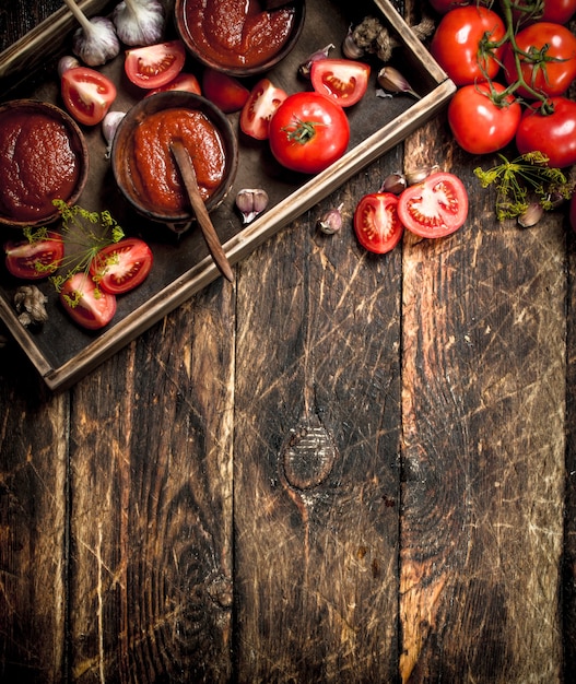 Salsa di pomodoro con spezie e aglio nel vecchio vassoio.